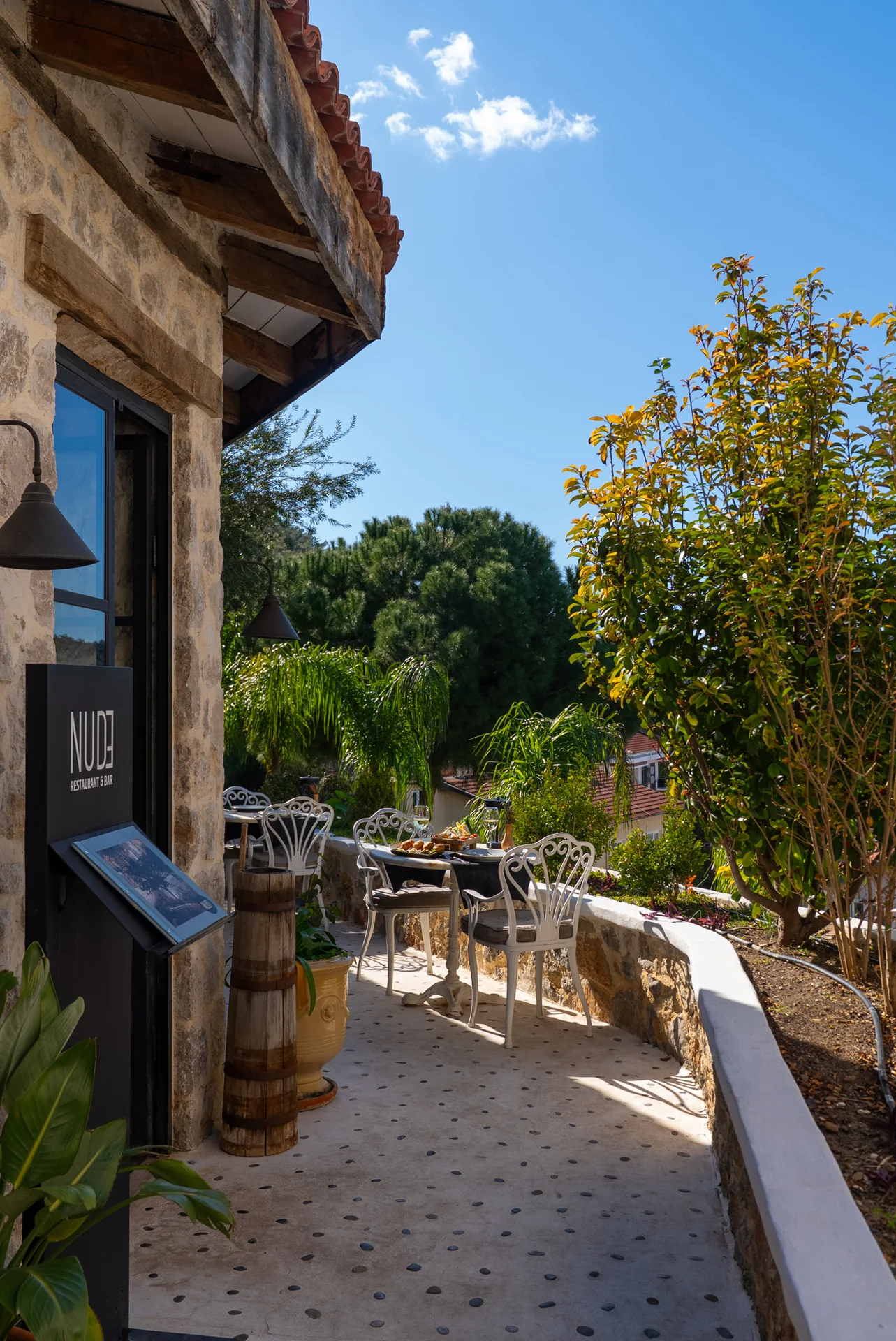Nude Restaurant ağaçlar altında teras masası